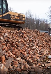 Погрузка боя красного кирпича экскаватором JCB. Утилизация строительного мусора, переработка и продажа вторичных материалов в СПб и области от Real Company.