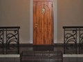 Квартирная дверь с наружной отделкой МДФ в пленке ПВХ и декоративной ручкой-стучалкой Лев.