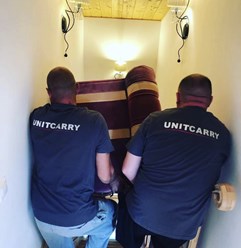 Процесс выноса мебели со второго этажа дачного дома.