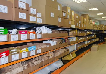 Картонные коробки, бумажные крафт пакеты и другие товары на полках магазина