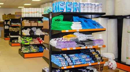 Полки с товаром: туалетная бумага, одноразовые продуктовы и мусорные пакеты, перчатки и другая продукция