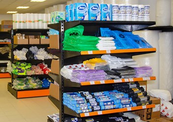 Полки с товаром: туалетная бумага, одноразовые продуктовы и мусорные пакеты, перчатки и другая продукция