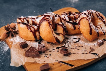 Многогранный вкус темного шоколада на свежем классическом пончике заполнит пространство вокруг теплом и подарит заряд бодрости для важных дел.