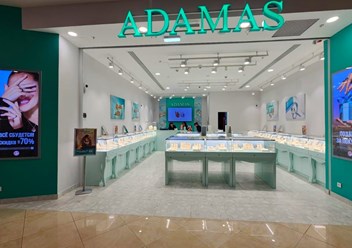 Готовый бутик Adamas после ремонта: фирменные зелёные акценты, стеклянные витрины, яркое торговое освещение. Ремонт ювелирного магазина под ключ.