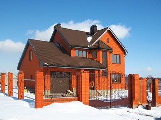 Фасад дома выполнен из красного одинарного кирпича, а забор сделан из утолщённого красного Старооскольского кирпича с вставками из одинарного кирпича цвета мокко. Красивое сочетание кирпичной кладки