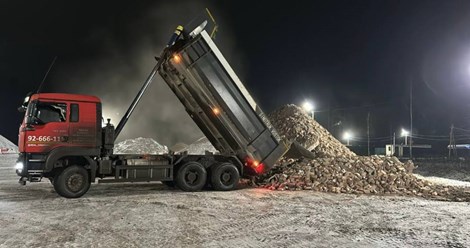 Круглосуточная доставка щебня в СПб. Самосвал Real Company разгружает гранитный щебень в ночное время для бесперебойного строительства объекта.