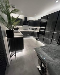 Глянцевая черная кухня со столешницей из кварца.