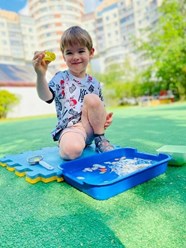 Исследуем мир вокруг!
Мальчик на свежем воздухе с лупой и лотком воды — занятие по сенсорному развитию и элементарной науке. Здесь дети учатся наблюдать, исследовать и задавать вопросы.