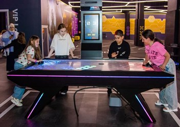Компания детей играет в клубе виртуальной реальности BAZA VR