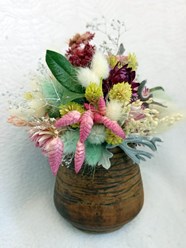 Букет из сухоцветов и стабилизированных цветов в керамической вазе ручной работы.