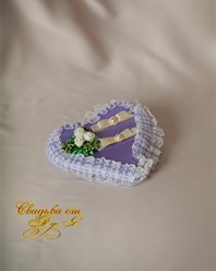 Подушка для колец на свадьбу в виде сердца, сиреневого цвета из атласной ткани. Декорирована подушка нежным кружевом, украшена розочками из латекса белого цвета и жемчужными бусинами.