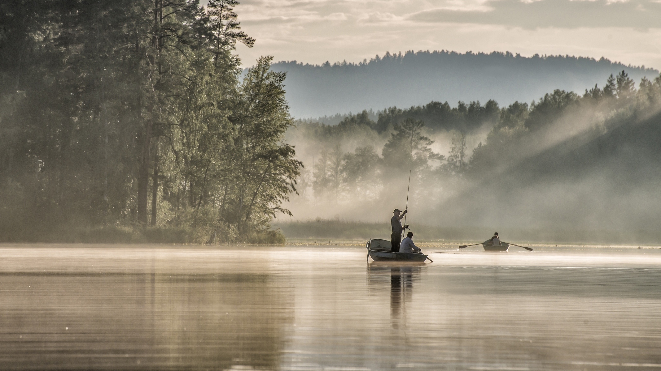 С утра сидит на озере. Рыбак в лодке на озере. Лодка в тумане. Пейзаж с рыбаком. Пейзаж с лодкой.